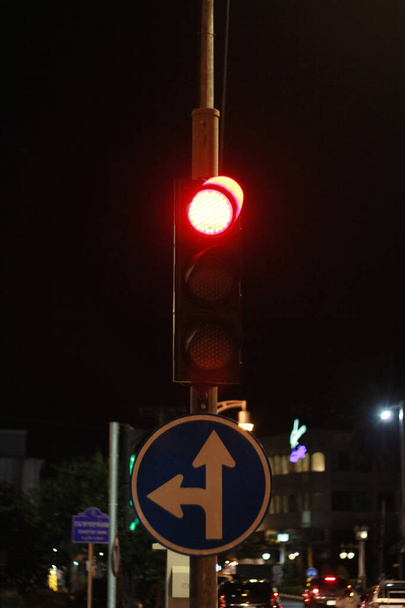 semáforos com luz vermelha para parar, sinal de estrada vire à esquerda e vá em frente na cidade. - Foto, Imagem
