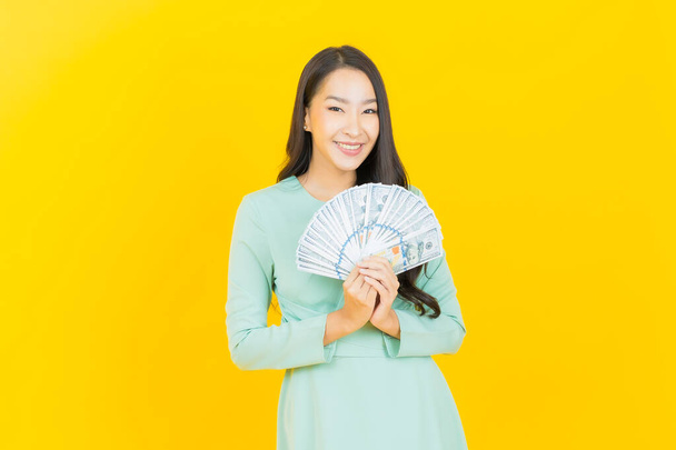 Portret piękna młoda azjatycka kobieta uśmiech z dużą ilością gotówki i pieniędzy na tle koloru - Zdjęcie, obraz