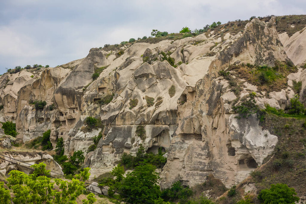 Incríveis formações rochosas vulcânicas conhecidas como Love Valley ou Fairy Chimneys na Capadócia, Turquia. Mushroom Valley uma das atrações do Parque Nacional Goreme, na Turquia. Montanhas com quartos dentro - Foto, Imagem