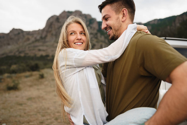 Happy loving couple hiking and hugging in mountains - Фото, изображение