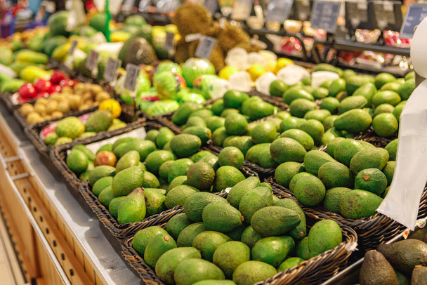 Bündel frischer grüner Avocados im Supermarkt - Foto, Bild