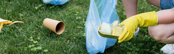 Cropped view of woman holding tin can and garbage bag outdoors, banner  - Foto, Imagem