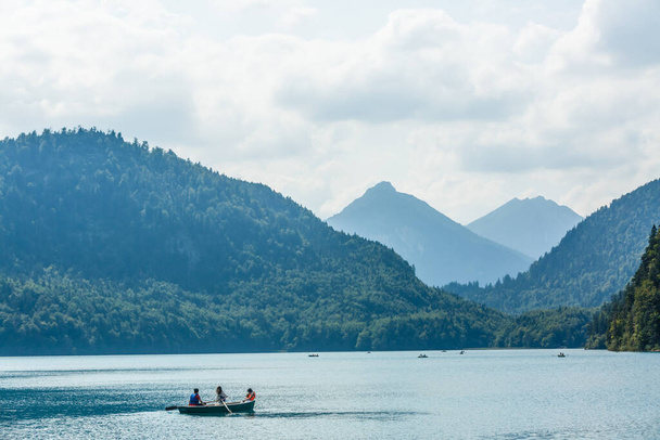 Descanse en un lago de montaña cerca de Neuschwanstein. familia está sentada en el barco - Foto, imagen