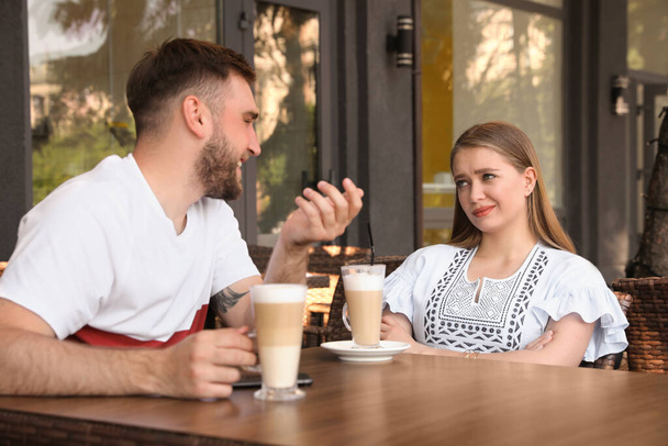 Young woman having boring date with talkative guy in outdoor cafe - Foto, Bild