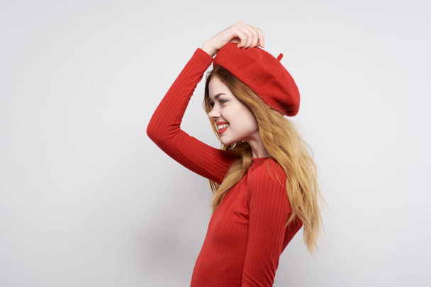 όμορφη γυναίκα με κόκκινο καπέλο στο φως φόντο. Υψηλής ποιότητας φωτογραφία - Φωτογραφία, εικόνα