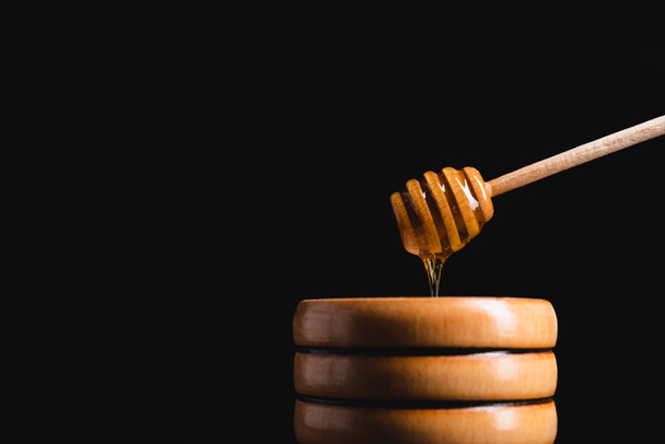 nestemäinen hunaja virtaa dipper pieneen puinen tynnyri eristetty musta - Valokuva, kuva