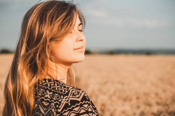 face profile of romantic young woman enjoying sunset nature on wheat field, girl breathe breathes deeply , freedom and relaxation concept - Foto, Imagem