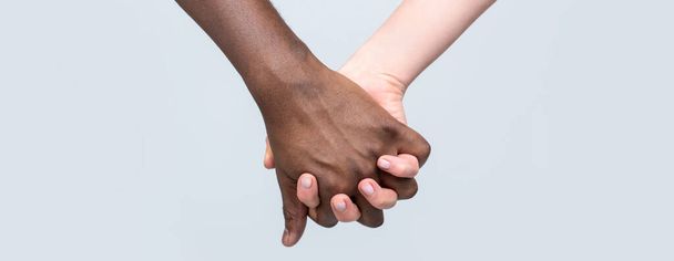 Λευκή γυναίκα, Αφρικανός που κρατάει το Σύμβολο Φιλίας. Αφρικανικό Σύμβολο Ειρήνης. Μικτή φυλή ζευγάρι κρατώντας τα χέρια. Ασπρόμαυρο χέρι. Μαύρη, λευκή γυναίκα και άντρας - Φωτογραφία, εικόνα