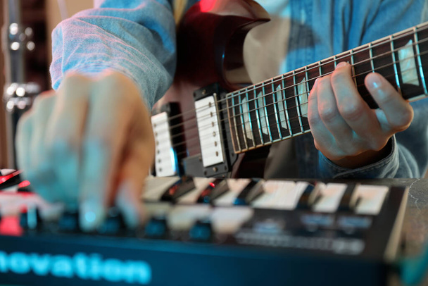 Μουσικός που παίζει σε ηλεκτρική κιθάρα και midi πληκτρολόγιο, κοντινό πλάνο - Φωτογραφία, εικόνα