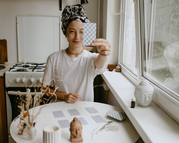 жінка з картками таро на білій кухні
 - Фото, зображення