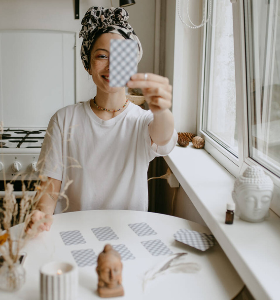 женщина с карточками Таро на белой кухне - Фото, изображение