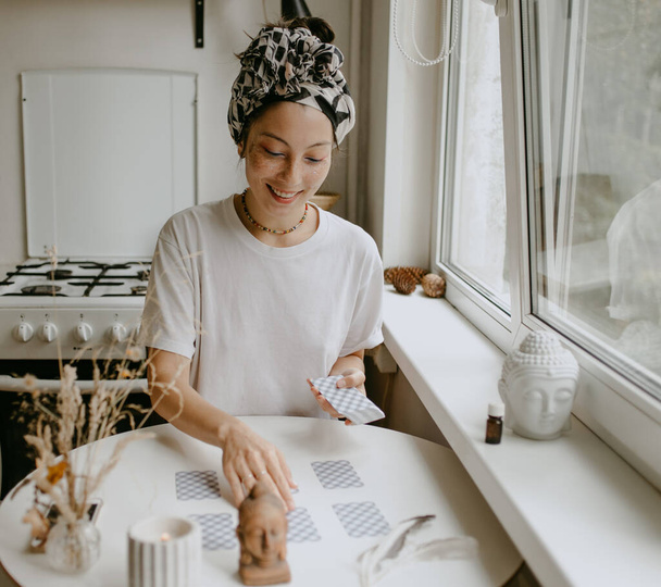 mulher com cartas de tarô na cozinha branca - Foto, Imagem