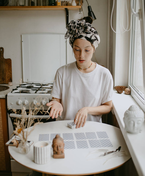 žena s tarotovými kartami na bílé kuchyni - Fotografie, Obrázek