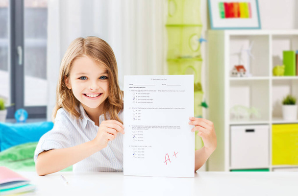 student girl with school test and A grade at home - Valokuva, kuva
