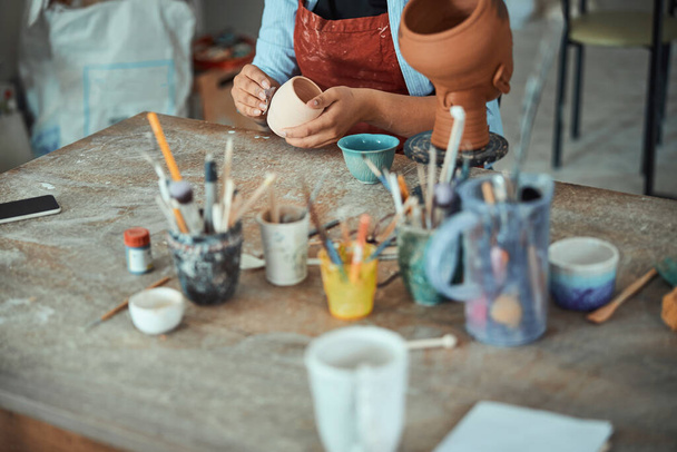 陶芸教室で陶芸家の女性の手が陶磁器を支える - 写真・画像