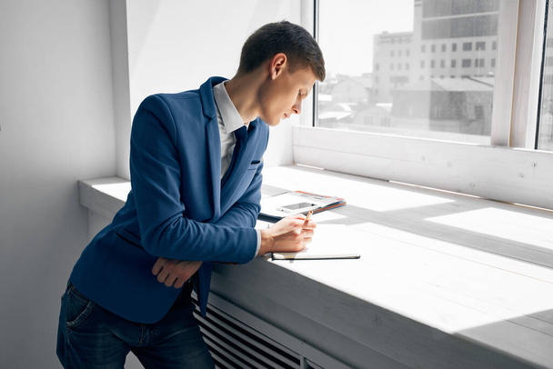 mężczyzna w garniturze przy oknie praca dokumenty profesjonalny biznesmen - Zdjęcie, obraz