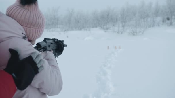 Nuori tyttö ampuu kiväärin ohjaajan tuella ja iloitsee osumasta kohteeseen - Materiaali, video