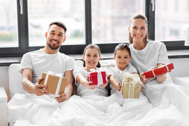šťastná rodina s vánočními dárky v posteli doma - Fotografie, Obrázek