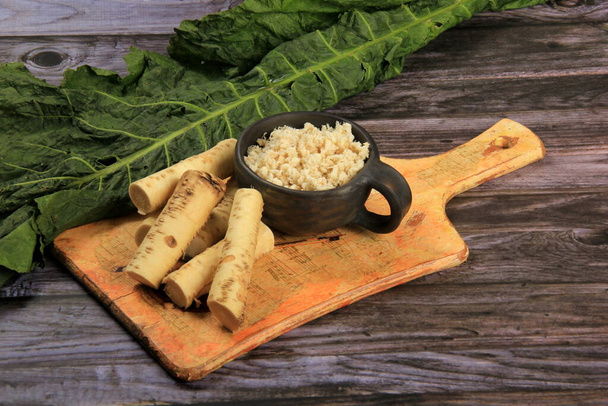 Fresh grated Horseradish roots on wooden table. The root of horseradish - Photo, Image