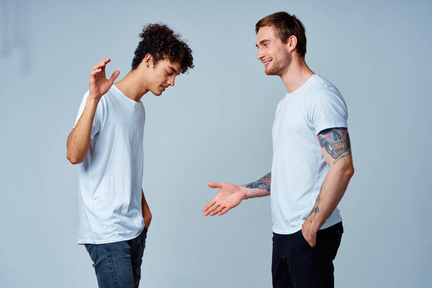 two men in t-shirts friendship communication light background - Zdjęcie, obraz