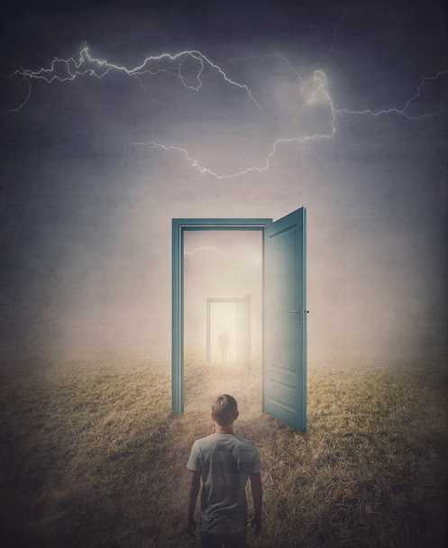 Концепция телепортационных дверей. Задний вид человека, стоящего перед дверью в стране, как в зеркале, как портал в другой мир. Волшебная и сюрреалистическая сцена со страшными молниями - Фото, изображение