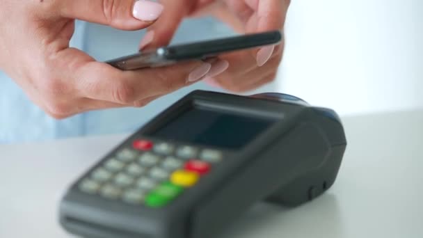 Contactless payment with smartphone. Wireless payment concept. Close-up, woman using smartphone cashless wallet NFC technology to pay order on bank terminal. - Footage, Video