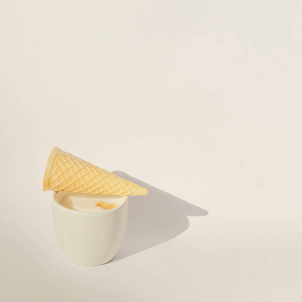 cup of coffee with ice cream cone empty on top of it.white aesthetic shadows concept design - Zdjęcie, obraz