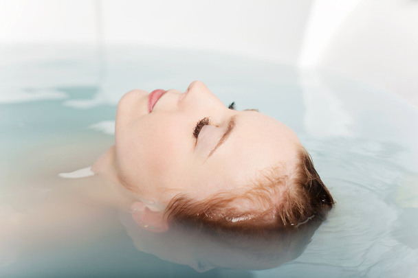 Woman soaking in bath tub - Photo, Image