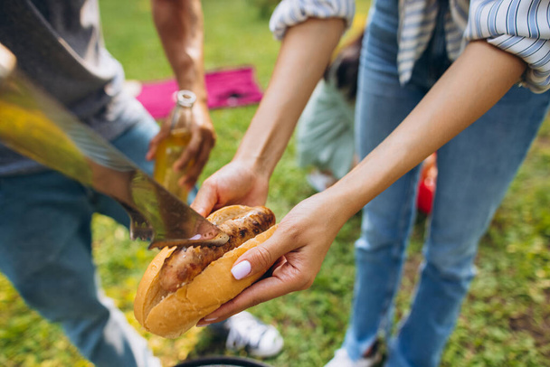 Portret młodych ludzi gotujących razem na piknik w ciepły letni dzień - Zdjęcie, obraz