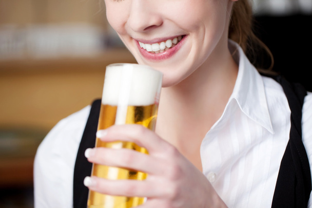 Woman with frothy pint of beer - Photo, Image