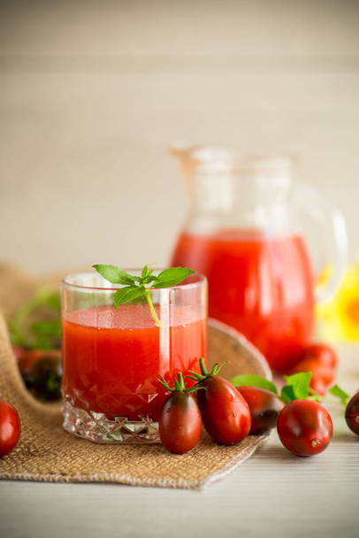 homemade freshly squeezed tomato juice with pulp in a glass decanter, on a wooden table. - Zdjęcie, obraz