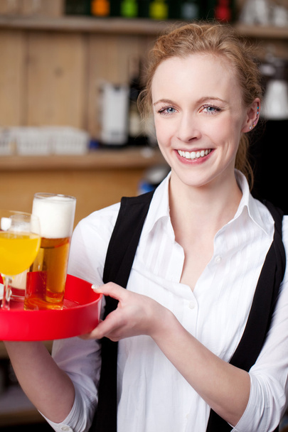 Bartender carrying tray of juice and beer - Valokuva, kuva