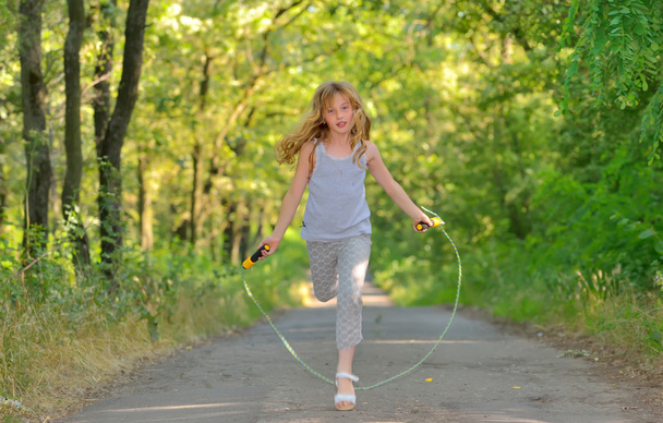 little girl jumps over rope - Foto, Bild