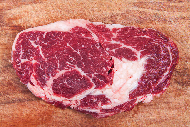  Friss nyers marhahús fából készült háttérrel. Sült marhahús.  - Fotó, kép
