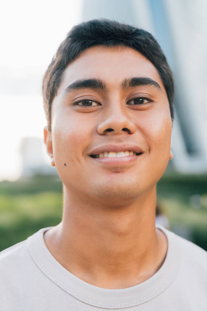 Retrato de joven asiático hombre al aire libre sonriendo positivo y saludable - Foto, Imagen