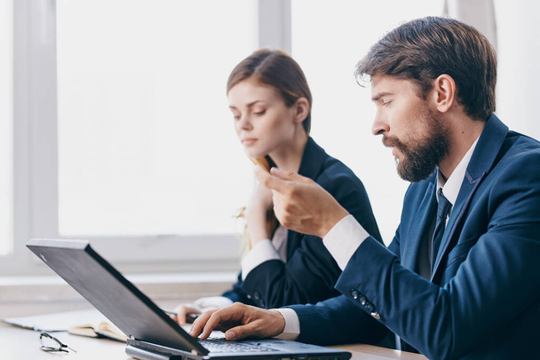 homme d'affaires et femme assis à un bureau avec un ordinateur portable technologies de communication - Photo, image
