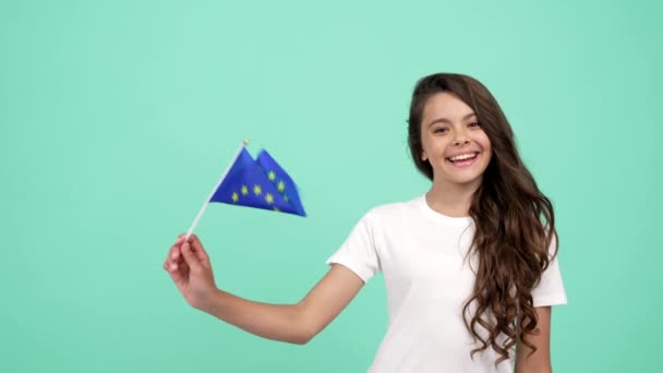 felice bambino sventola bandiera dell'unione europea su sfondo blu mostrando pollice in su, patriota - Filmati, video