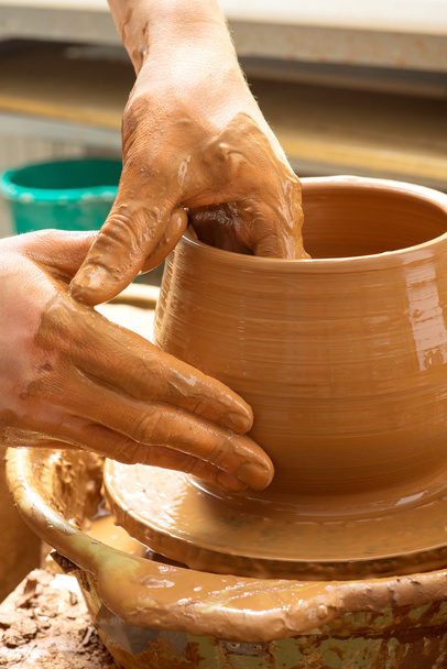 handen van een pottenbakker, het creëren van een aarden kruik - Foto, afbeelding