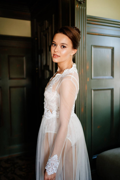 a beautiful bride in a lace robe in a room with a retro interior. - Fotografie, Obrázek