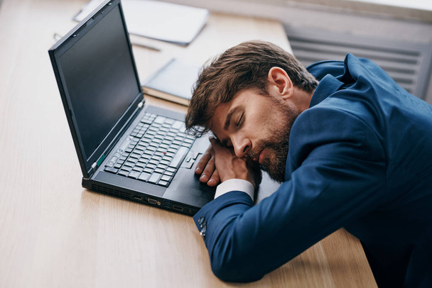 オフィスのノートパソコンの前で寝てるビジネスマン - 写真・画像