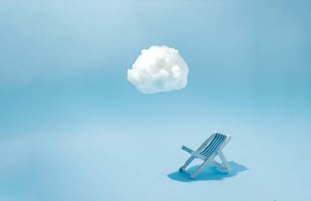 Καρέκλα παραλίας σε απόχρωση λευκού νέφους με μπλε φόντο. Ελάχιστη έννοια. - Φωτογραφία, εικόνα