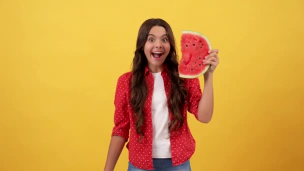 funny child point finger on water melon slice on yellow background, fruit - Footage, Video