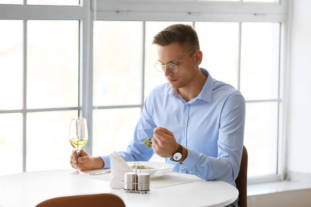 Young man eating tasty ravioli in cafe - Foto, Bild
