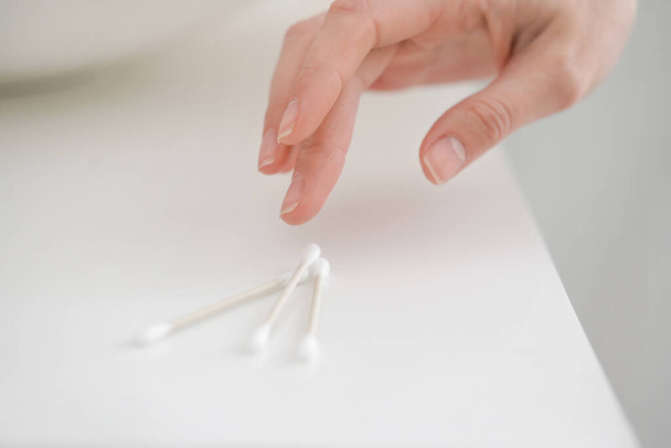 Young woman taking cotton bud from table, closeup - Foto, Imagen
