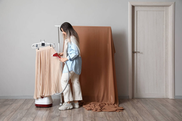 Estilista femenina preparando ropa para disparar en estudio fotográfico - Foto, Imagen