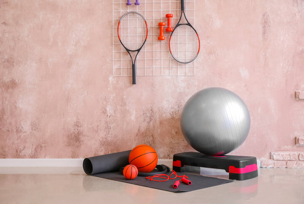 Different sports equipment  near color wall - Foto, afbeelding