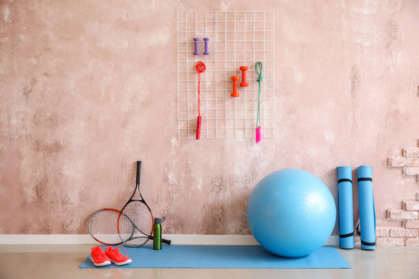 Different sports equipment  near color wall - Photo, Image