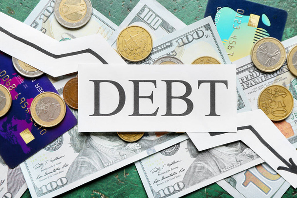 Paper with word DEBT and money on color background - Photo, Image