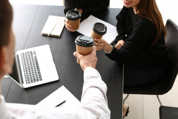 Business colleagues drinking coffee in office - Фото, зображення