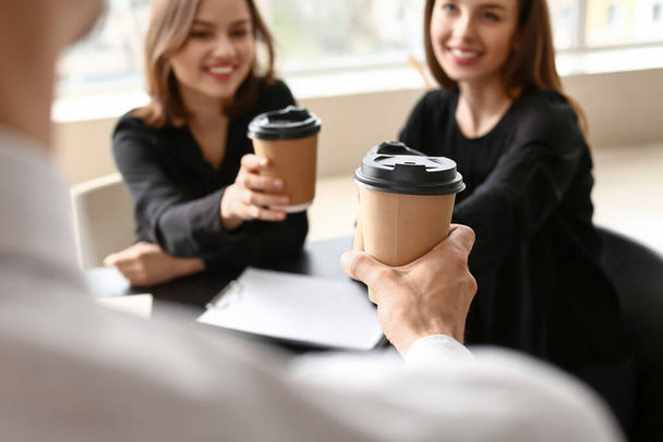 Business colleagues drinking coffee in office - 写真・画像